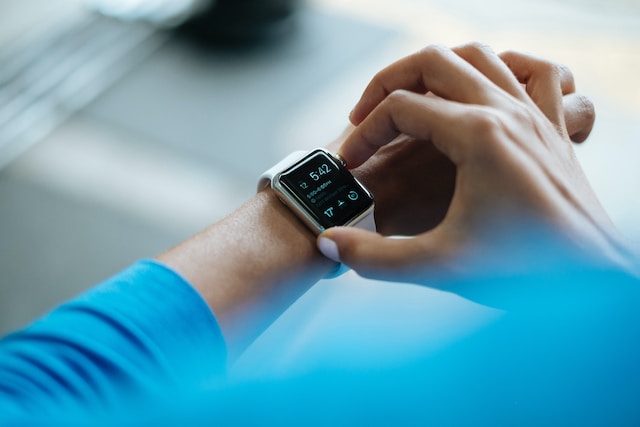 Person checking a smartwatch showing the time and activity data on their wrist