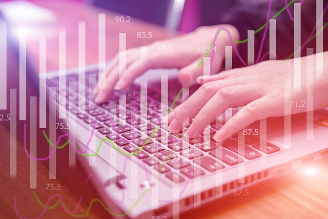 Hands typing on a laptop keyboard overlaid with financial chart lines and figures