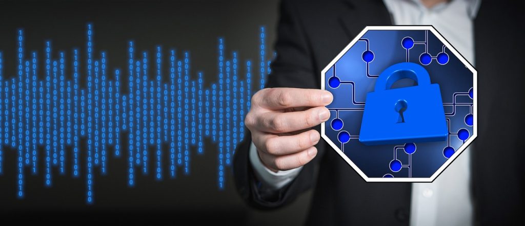 Businessman holding a padlock security icon beside streams of binary code