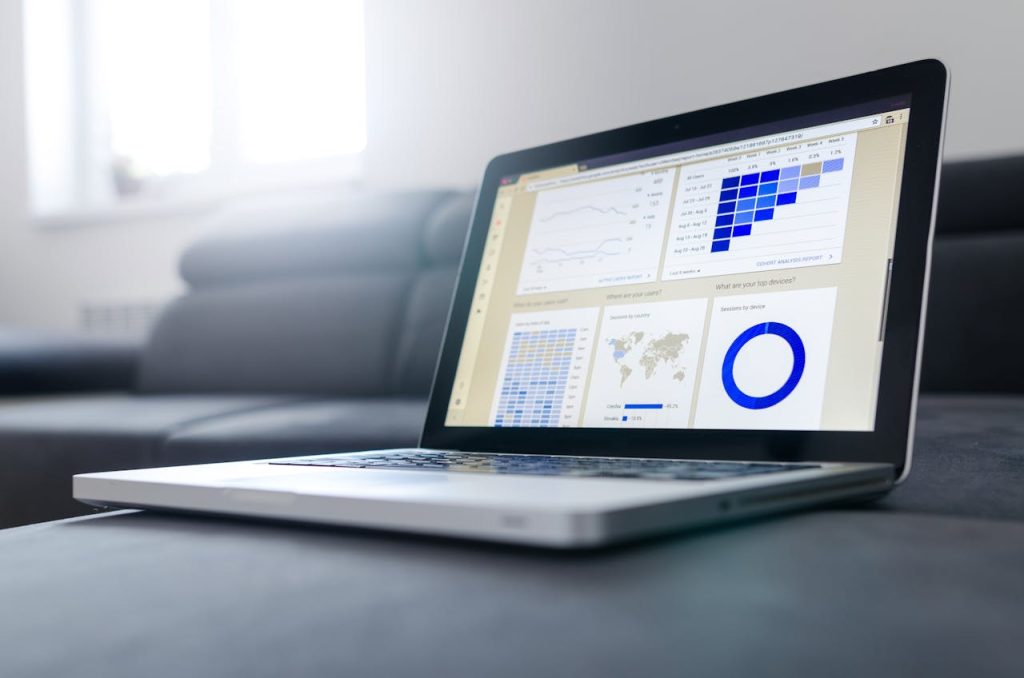 Laptop displaying an analytics dashboard with line charts, a heatmap and a world map