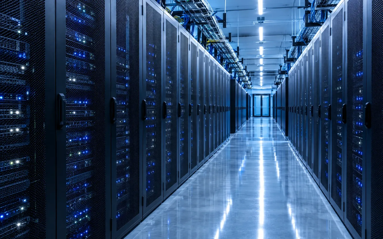 A data centre aisle lined with server racks and blue status lights